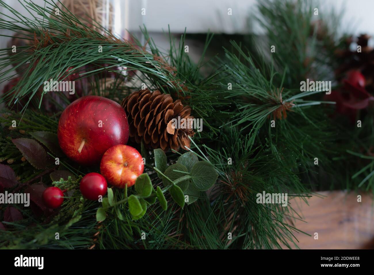 Verde terra di Natale con mele e coni di pino, sfondo Foto Stock
