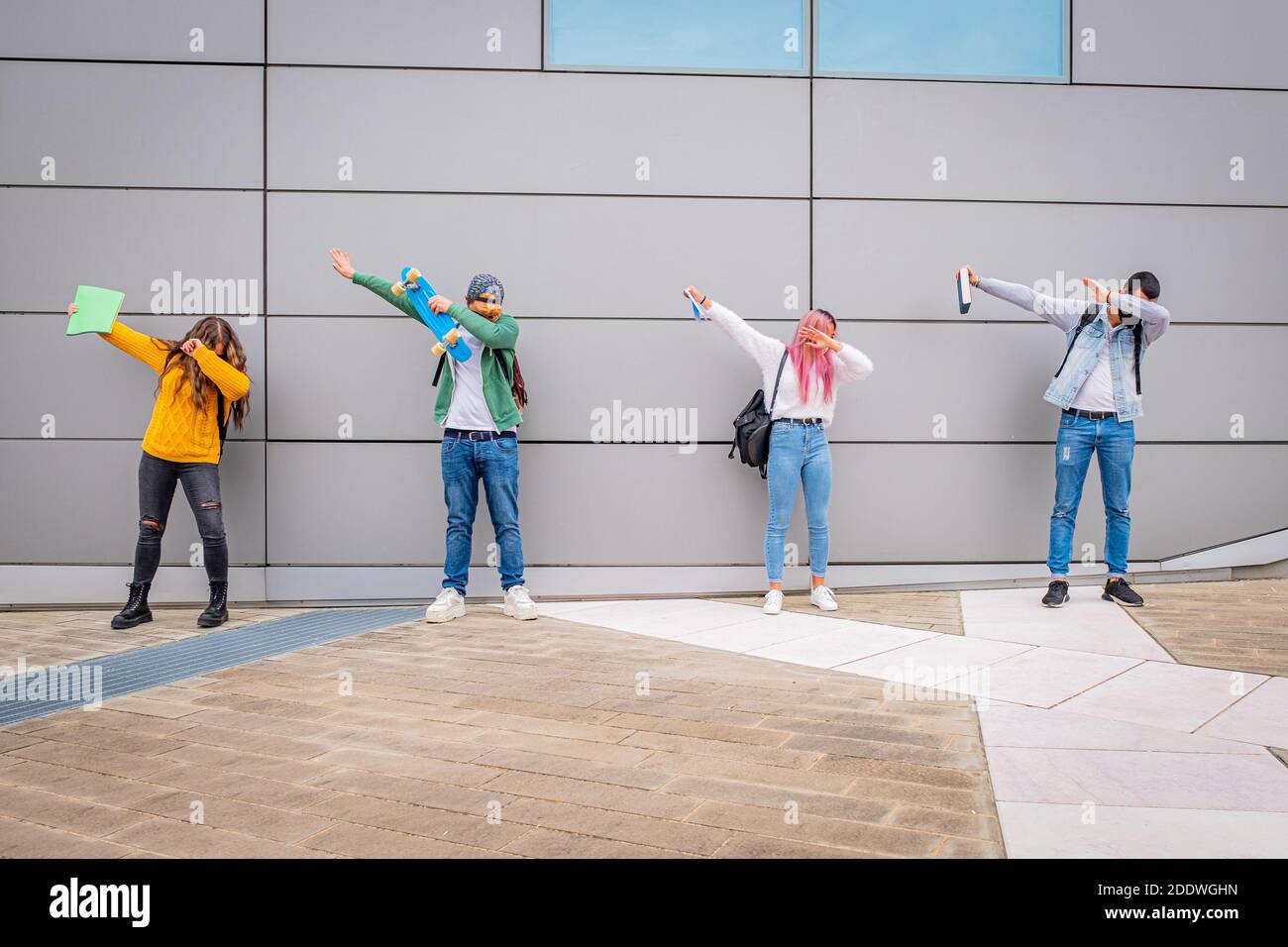 Persone multietniche che ballano la danza dab mantenendo la distanza sociale durante Il periodo del coronavirus - divertente studenti rendere divertente posa con prote Foto Stock