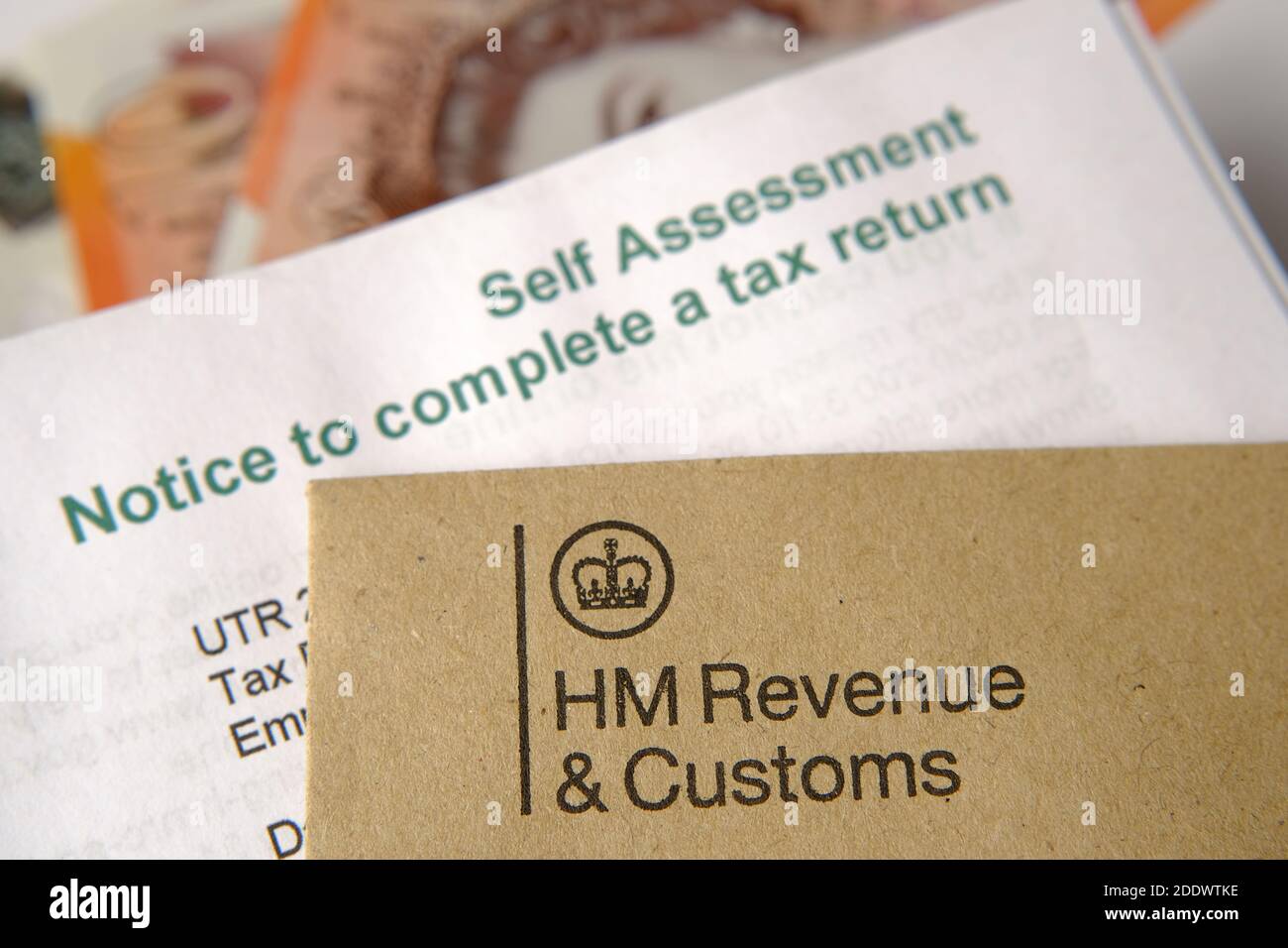 Lettere HMRC (Income and Customs) di HM visualizzate con i loghi con la busta marrone e l'autovalutazione e la lettera di avviso per la restituzione delle imposte sfocate. Foto Stock