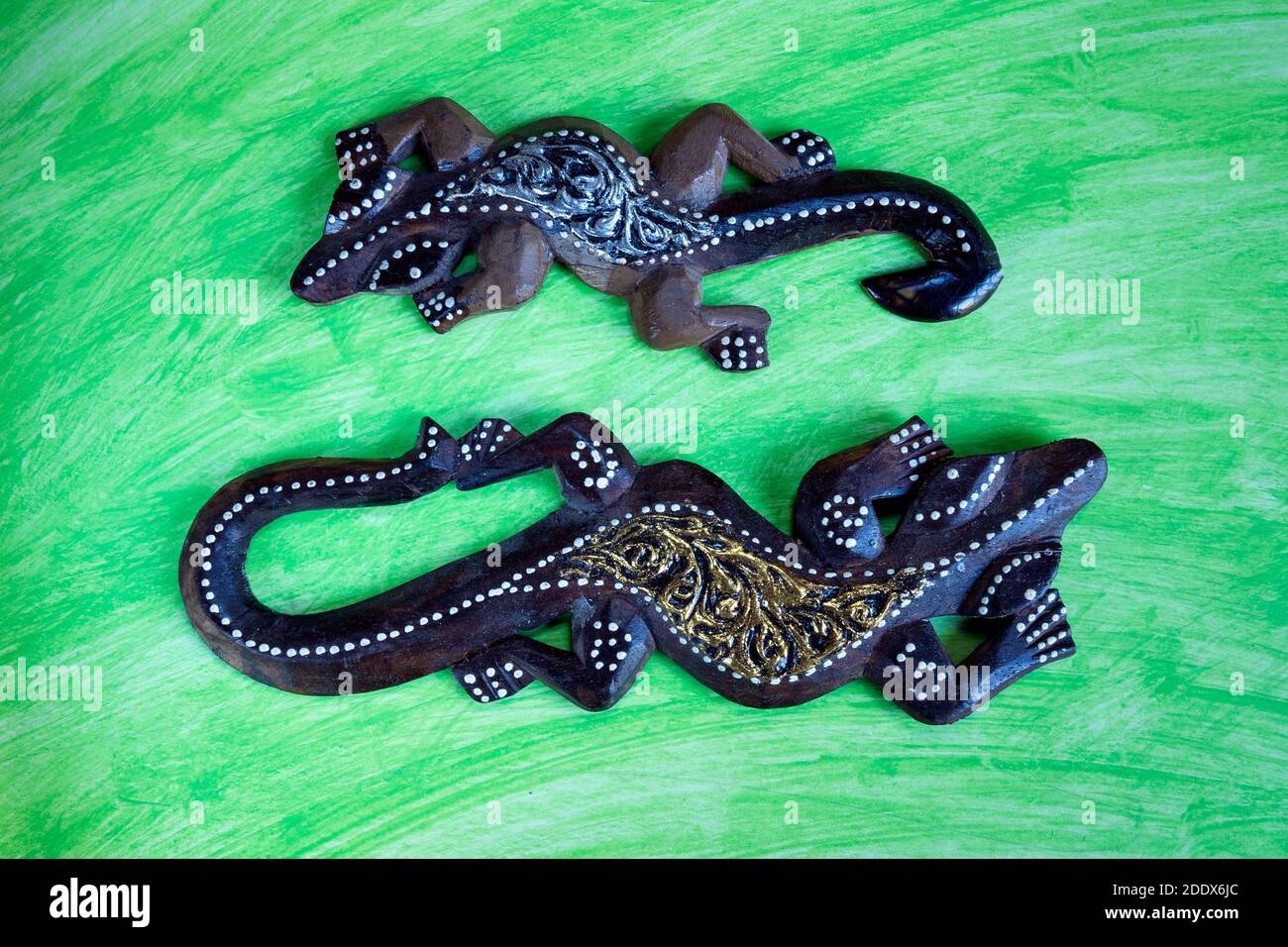 bambole colorate in geckos di legno su sfondo astratto acquerello. Foto Stock