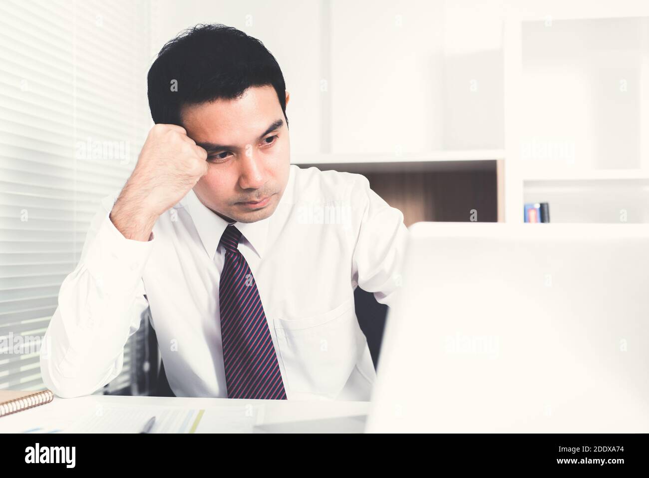 L'uomo d'affari asiatico che ottiene stressato (sconvolto) al lavoro Foto Stock