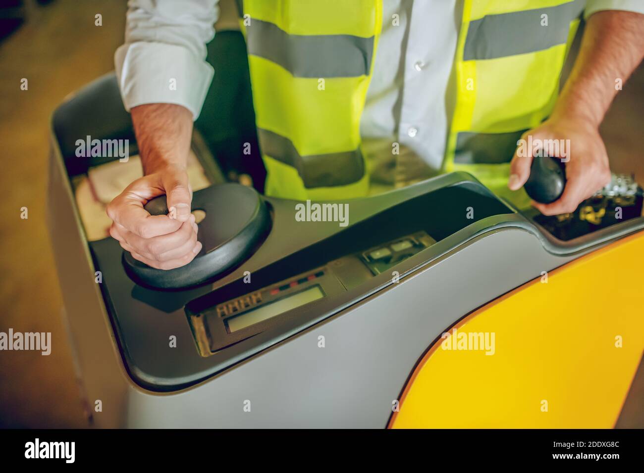 Primo piano immagine di lavoratore in giubbotto giallo Foto Stock