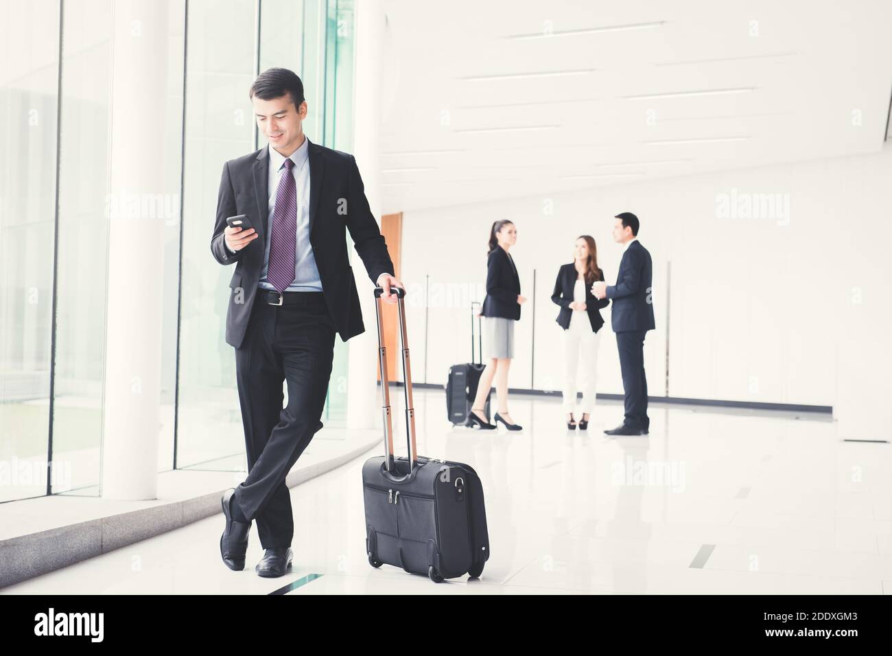 Uomini d'affari (assistenti di volo) con bagagli nel corridoio dell'edificio (terminal aeroportuale) Foto Stock