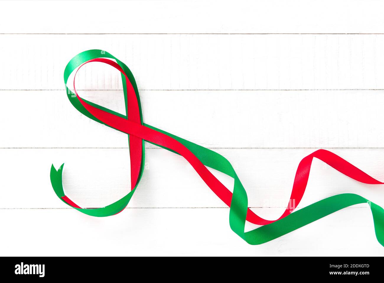 Nastro rosso e verde su sfondo di legno bianco Foto Stock