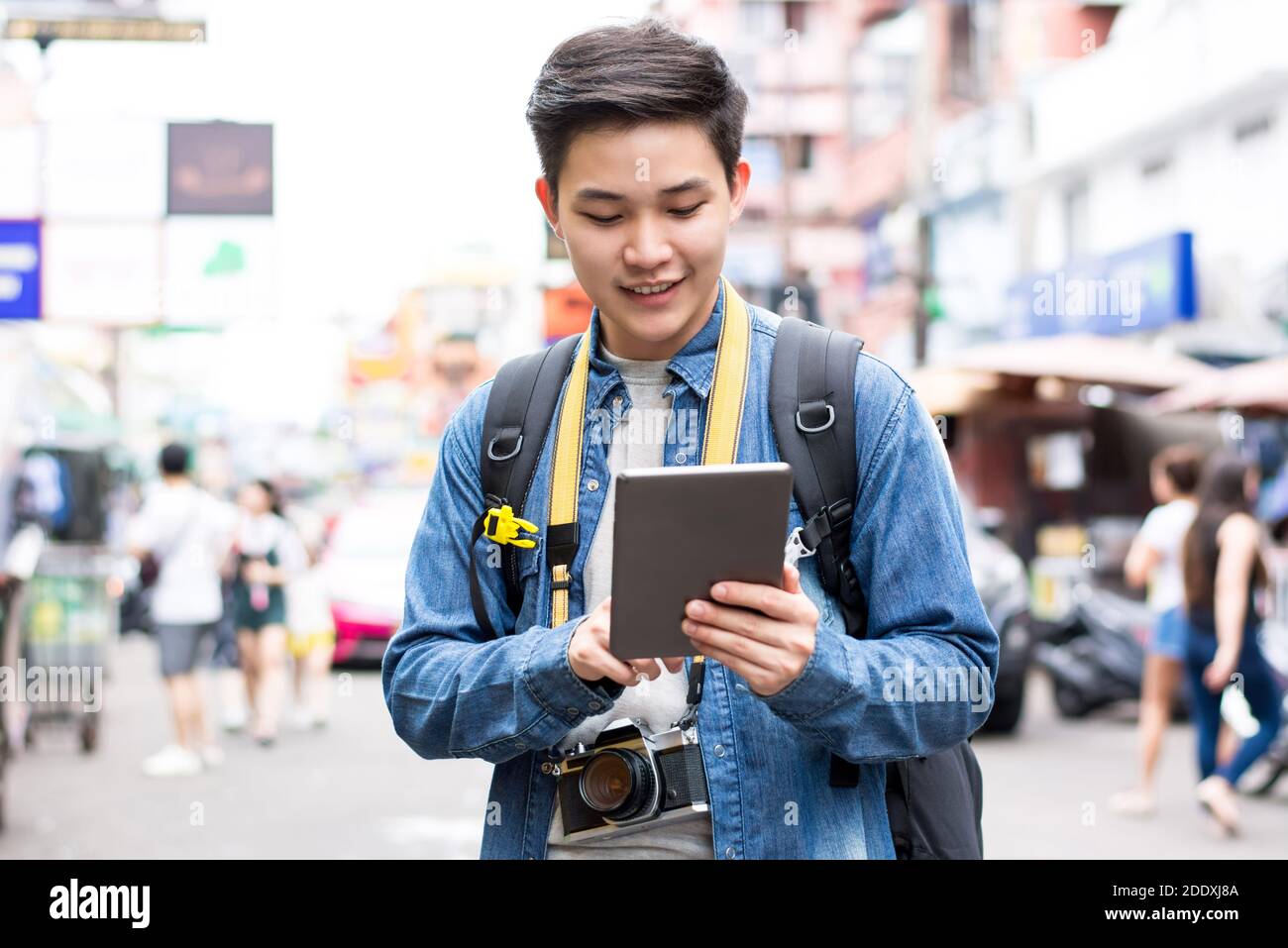 Asiatico fotografo turista zaino in spalla utilizzando tablet per trovare la posizione mentre Viaggiare in vacanza a Khao San Road Thailandia Foto Stock