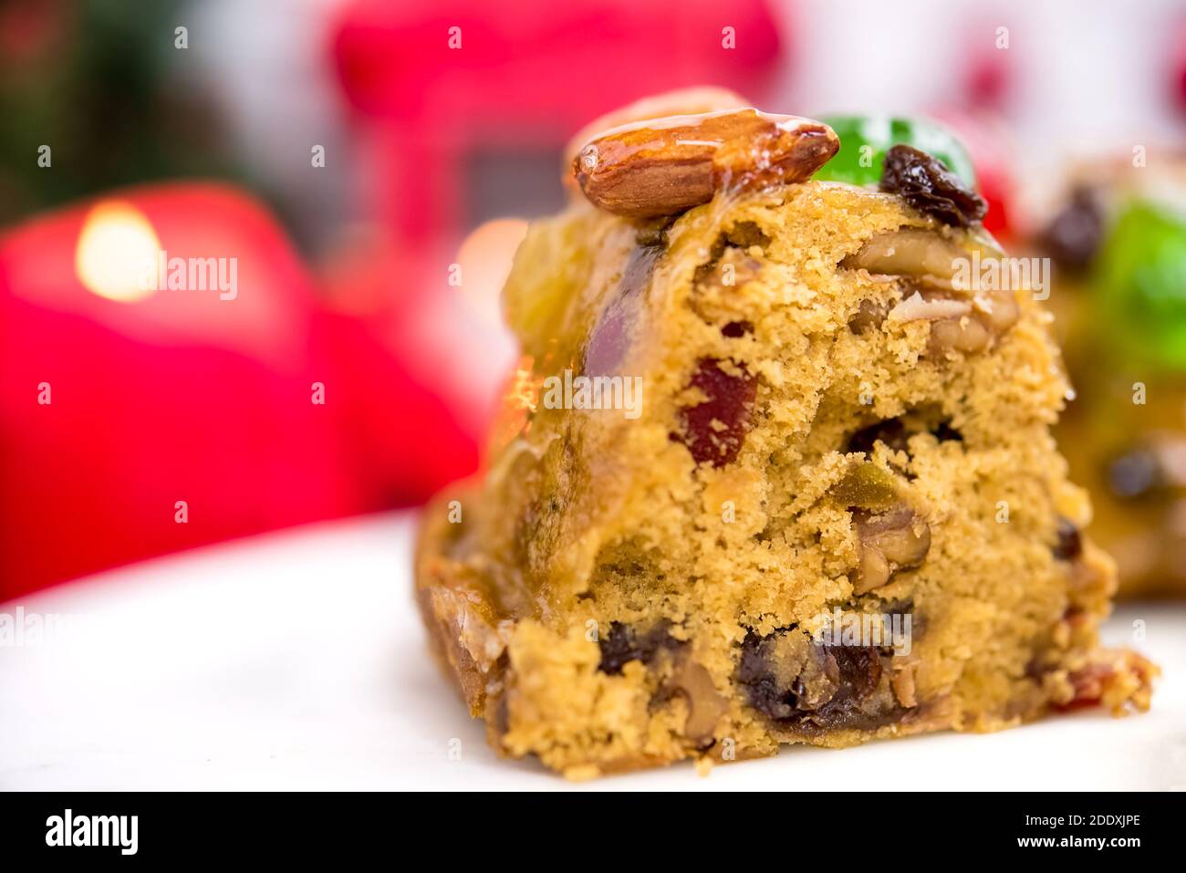 Primo piano di torta di frutta mista di Natale con sfumatura candele e decorazione oggetto in background preparato per celebrare festa stagione Foto Stock