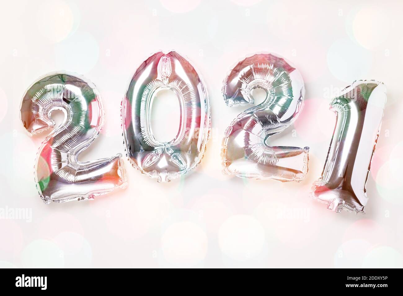 Palloncini d'argento in forma di numeri 2021 su sfondo bianco. Festa di nuovo anno. Buon anno 2021 concetti. Effetto bokeh - immagine Foto Stock