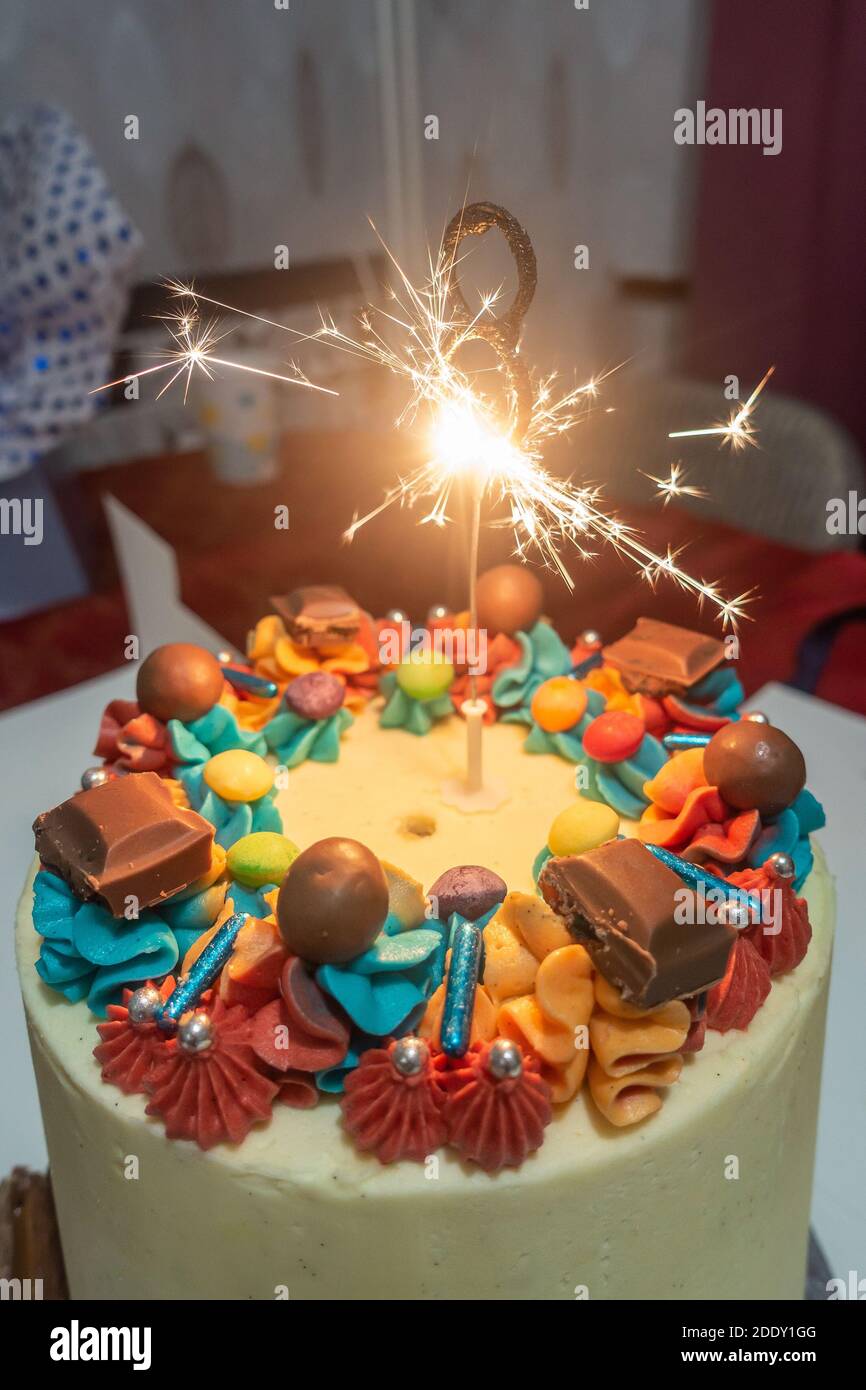 Una candela scintillante in cima a una torta di compleanno per un bambino di 8 anni. Foto Stock