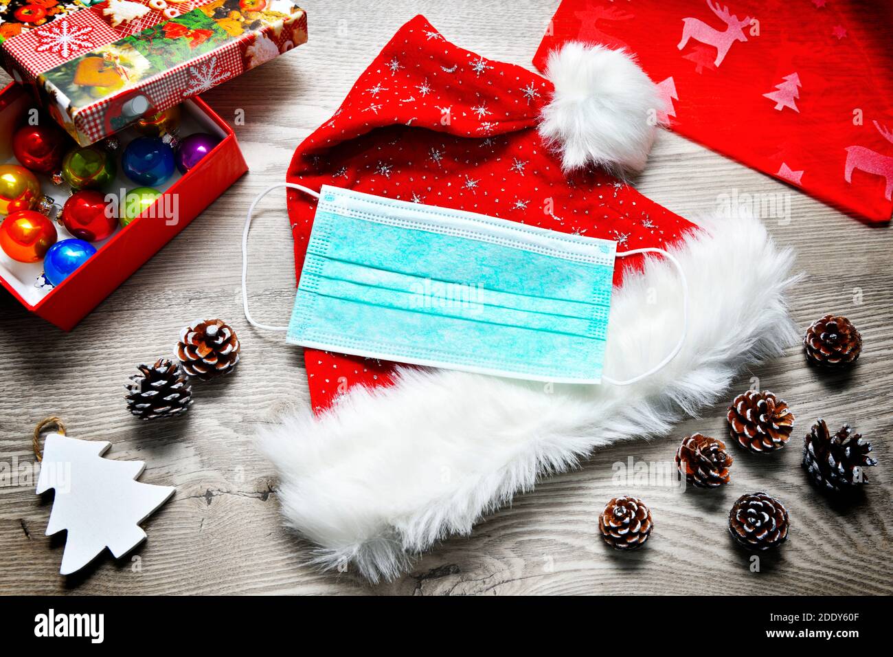 Maschera di faccia giacente sul cappello di Babbo Natale, Corona Foto Stock