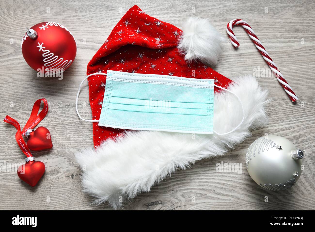 Maschera di faccia giacente sul cappello di Babbo Natale, Corona Foto Stock