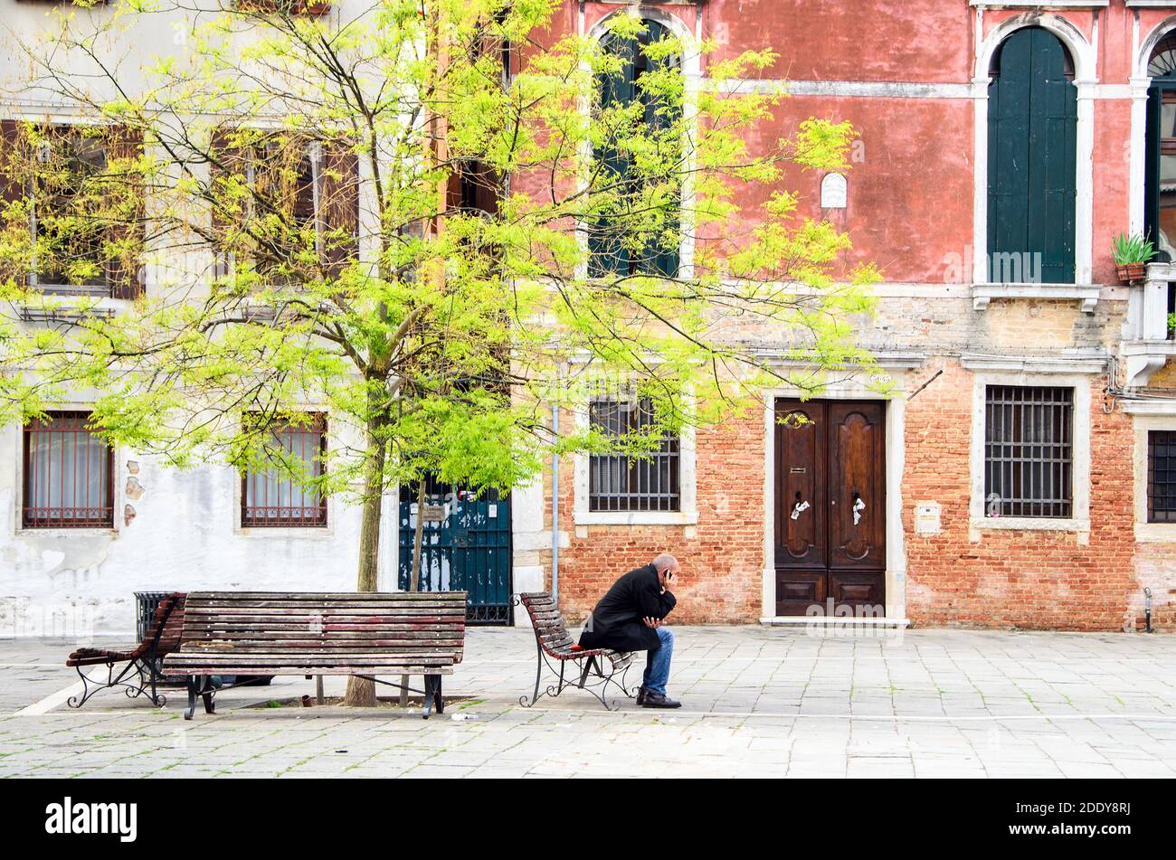 Uomo seduto su una panchina nel sestiere Dorsoduro - Venezia, Italia Foto Stock