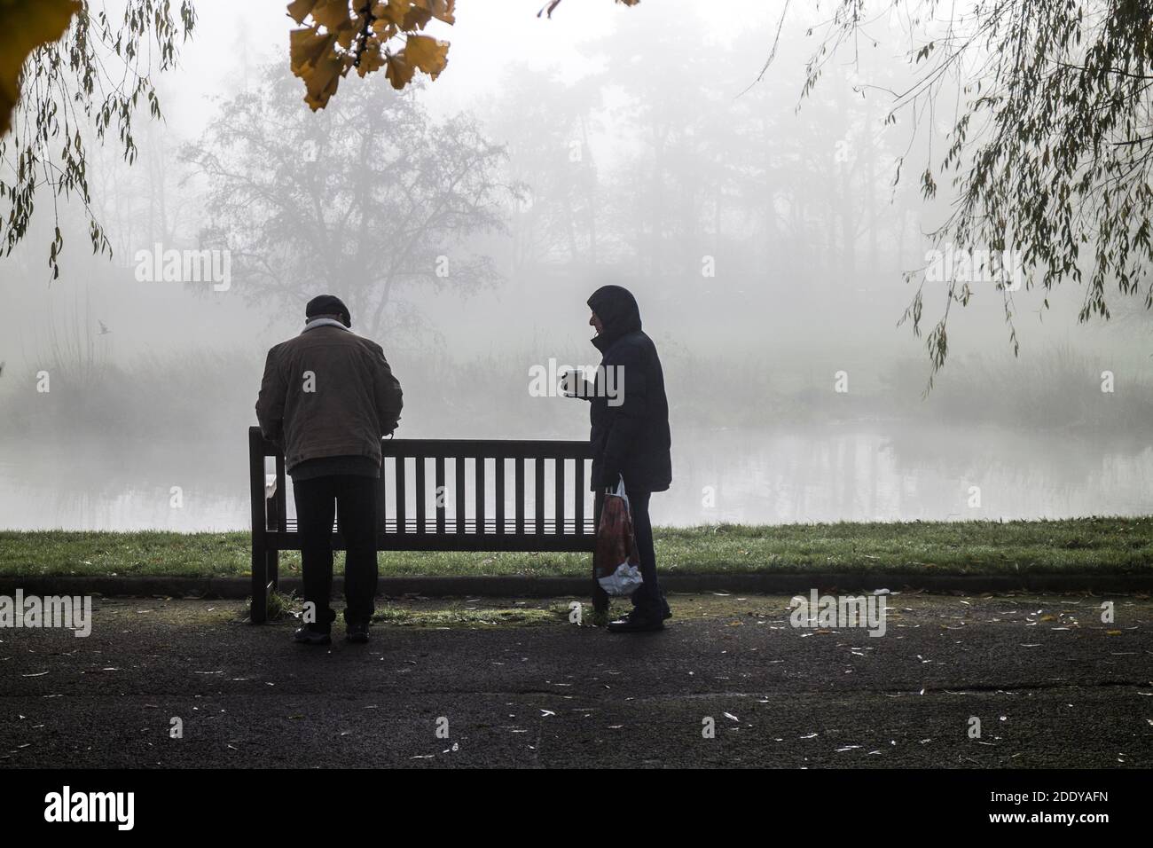 Due anziani lungo il fiume Avon in un giorno infelici di novembre, St. Nicholas Park, Warwick, Regno Unito Foto Stock