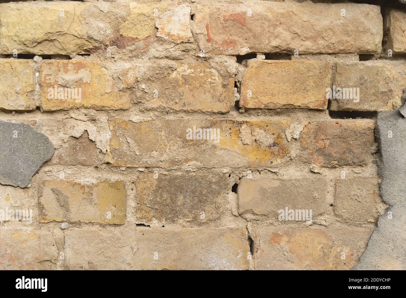 Struttura di muro esterno di mattoni con vecchio rivestimento caduto. Vecchio edificio con intonaco cadente. Sfondo di muro di mattoni modello Foto Stock