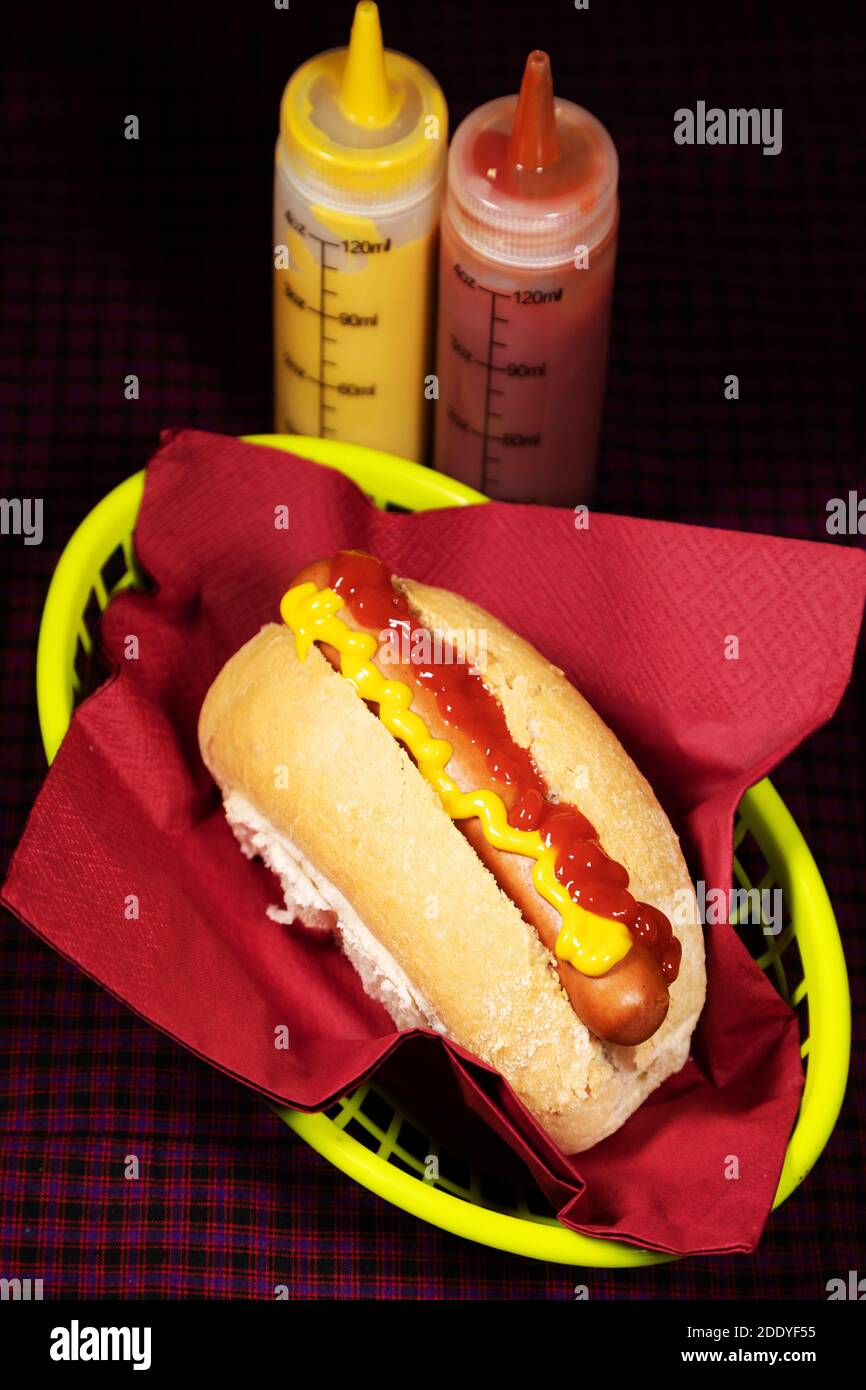 Hot dog serviti in un panino con ketchup e senape. Il panino viene servito in un cesto. Foto Stock
