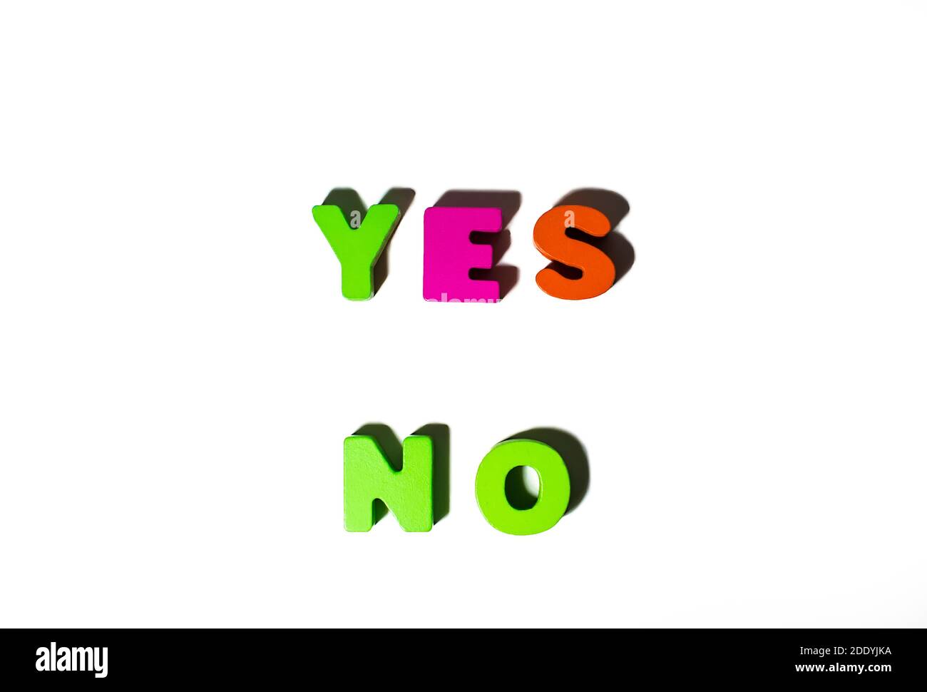 Due parole Sì No dalle lettere colorate dipinte in legno a. sfondo bianco con ombre Foto Stock