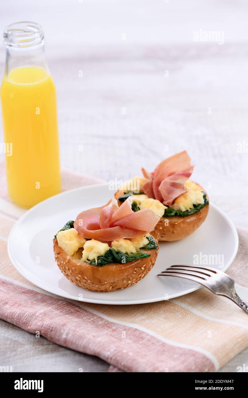 Colazione. Panino al forno con formaggio, spinaci, prosciutto e succo d'arancia Foto Stock