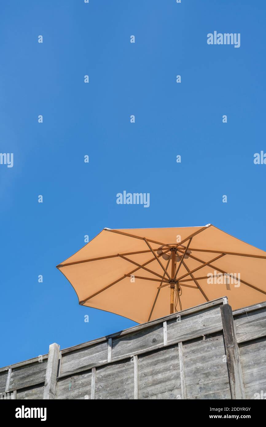 Indietro giardino sole ombrellone / ombrello contro il cielo estivo blu nuvoloso nel Regno Unito (come insolito). Vedere le note sull'area di interesse. Foto Stock