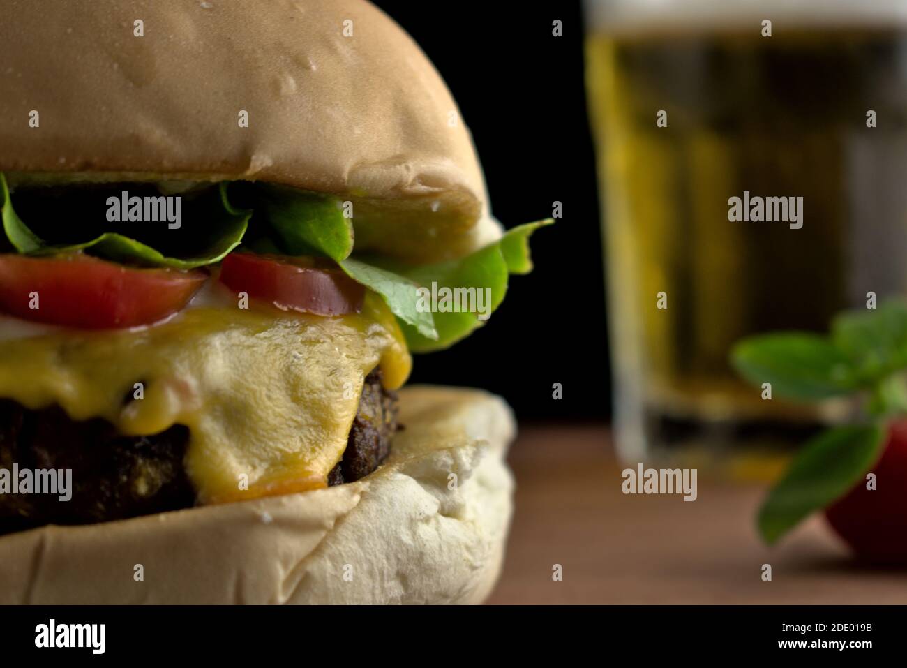 fotografia di un hamburger vegetariano con salsa di soia accompagnata da patate dolci fritte e birra feita in studio fotografico Foto Stock
