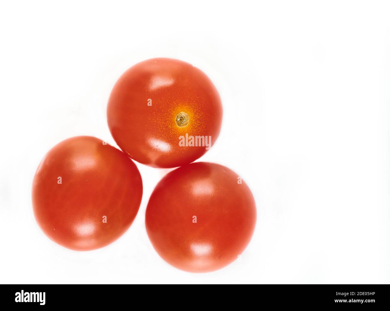 Trio di pomodori ciliegini rossi maturi lucidi Foto Stock