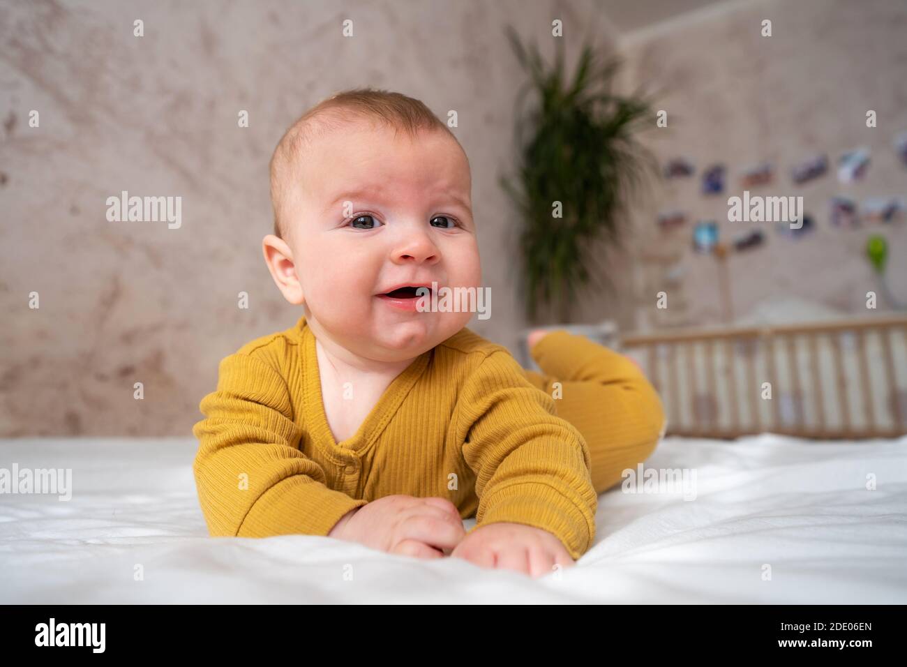 Ridere felice bambino bambino piccolo ragazzo con bocca aperta che si muove mani e gambe vista dall'alto Foto Stock