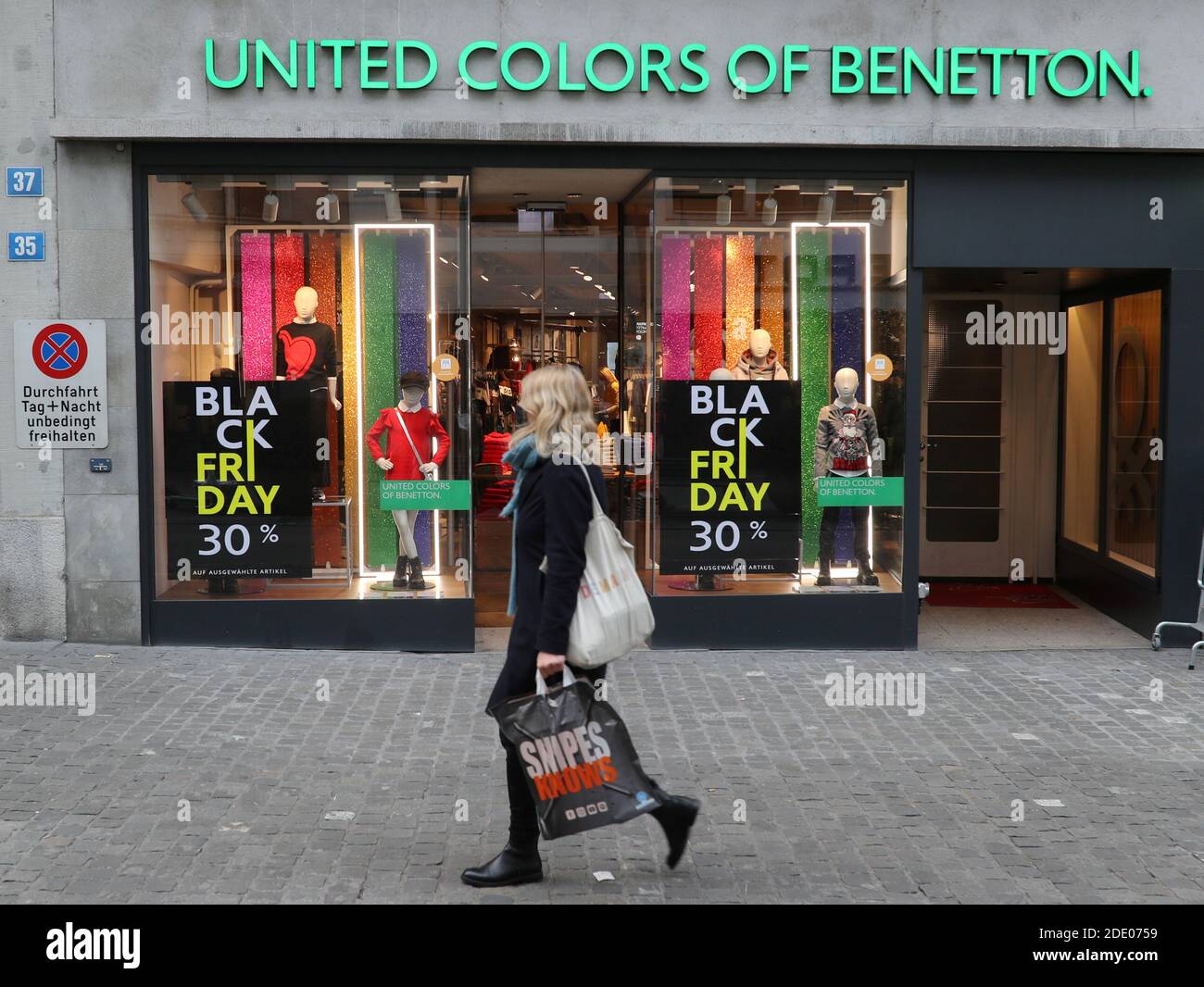 Poster che offrono uno sconto speciale sulle vendite del Black Friday sono  visti di fronte a un negozio di moda United Colors of Benetton Kid's, come  continua la diffusione della malattia del
