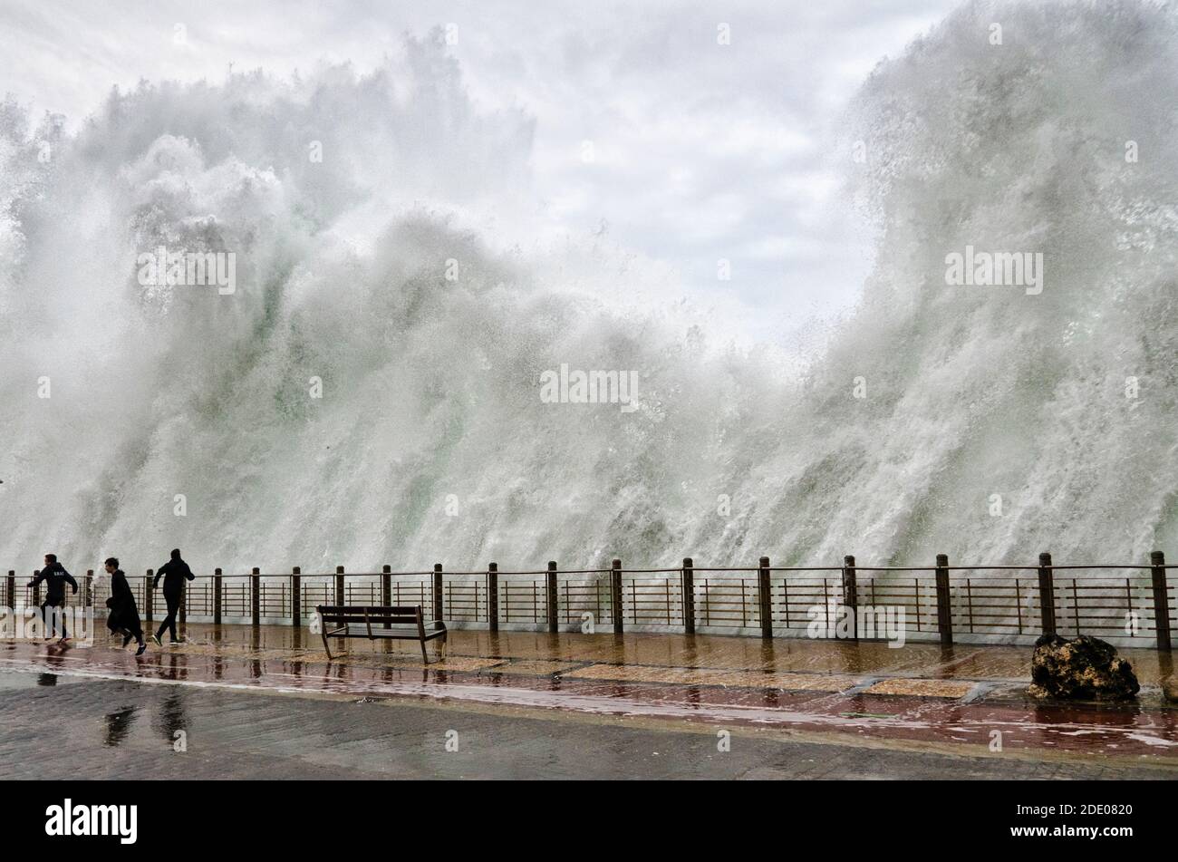 San Sebastián, Guipuzcoa, Spagna; 7 febbraio 2016; UN'enorme ondata cade sul lungomare costiero e su alcuni ragazzi Foto Stock