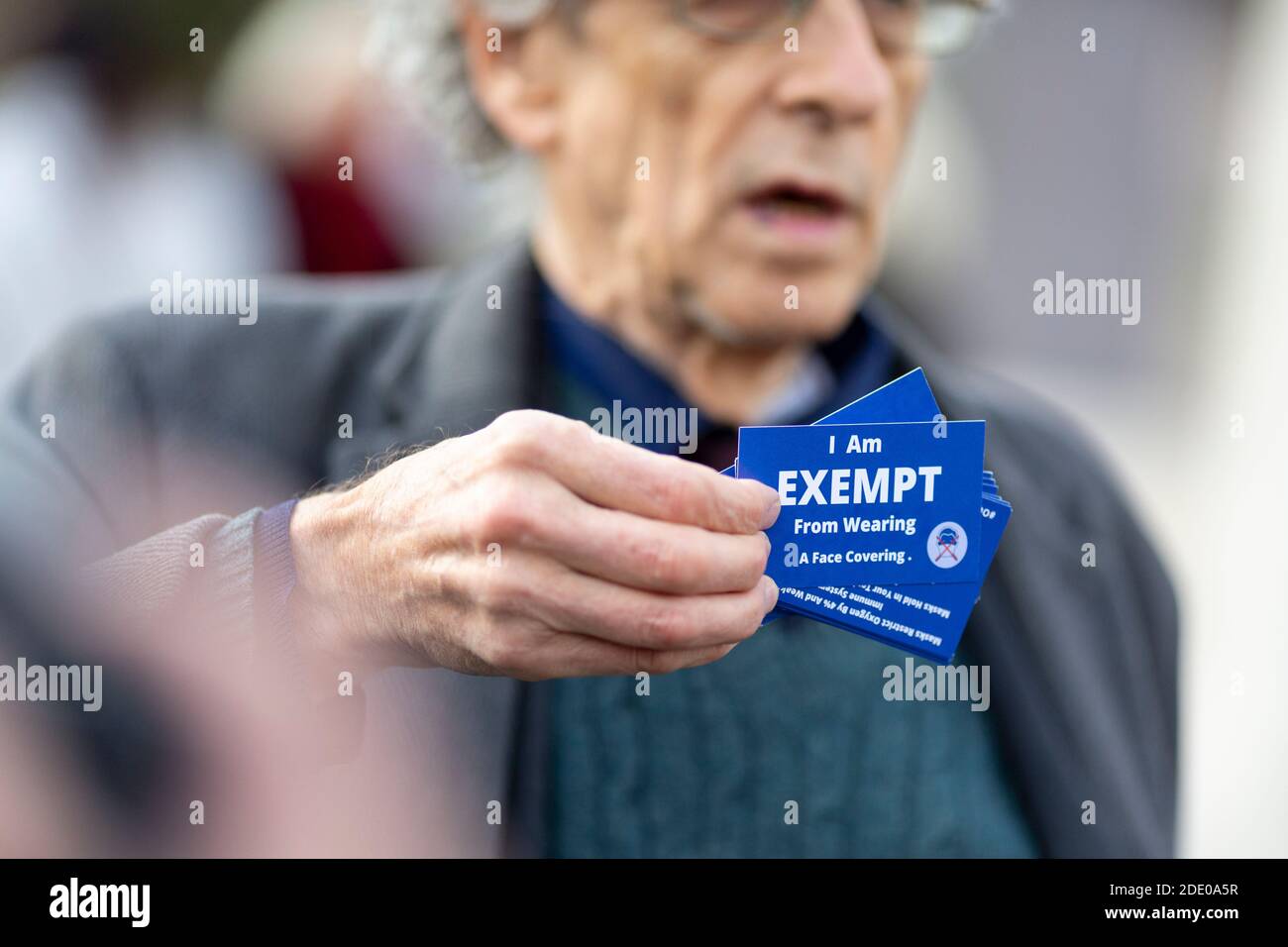 Piers Corbyn che tiene un volto che copre la tessera di esenzione durante la protesta contro la vaccinazione, Parliament Square, Londra, 24 novembre 2020 Foto Stock