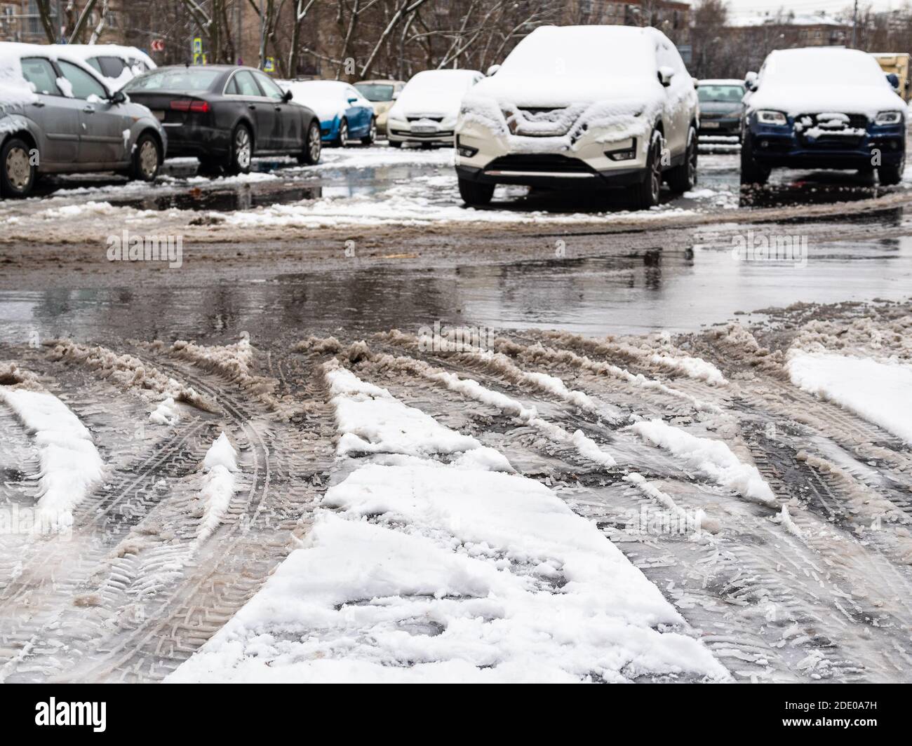 la prima neve che si scioglie sul parcheggio dell'auto a freddo giorno d'autunno Foto Stock
