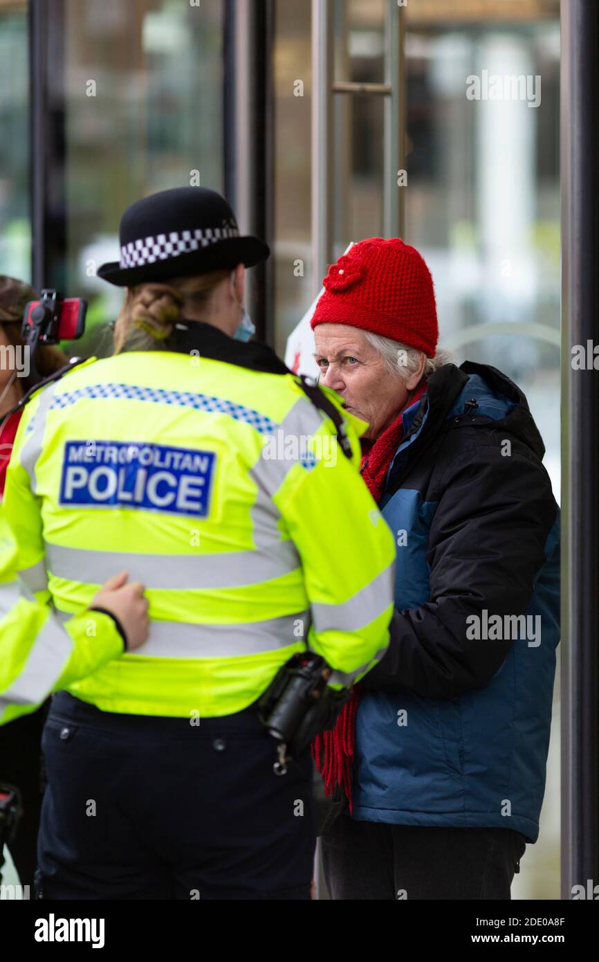 Un anziano manifestante parla con la polizia prima dell'arresto durante una protesta contro la vaccinazione, Bill and Melinda Gates Foundation Office, Londra, 24 novembre Foto Stock