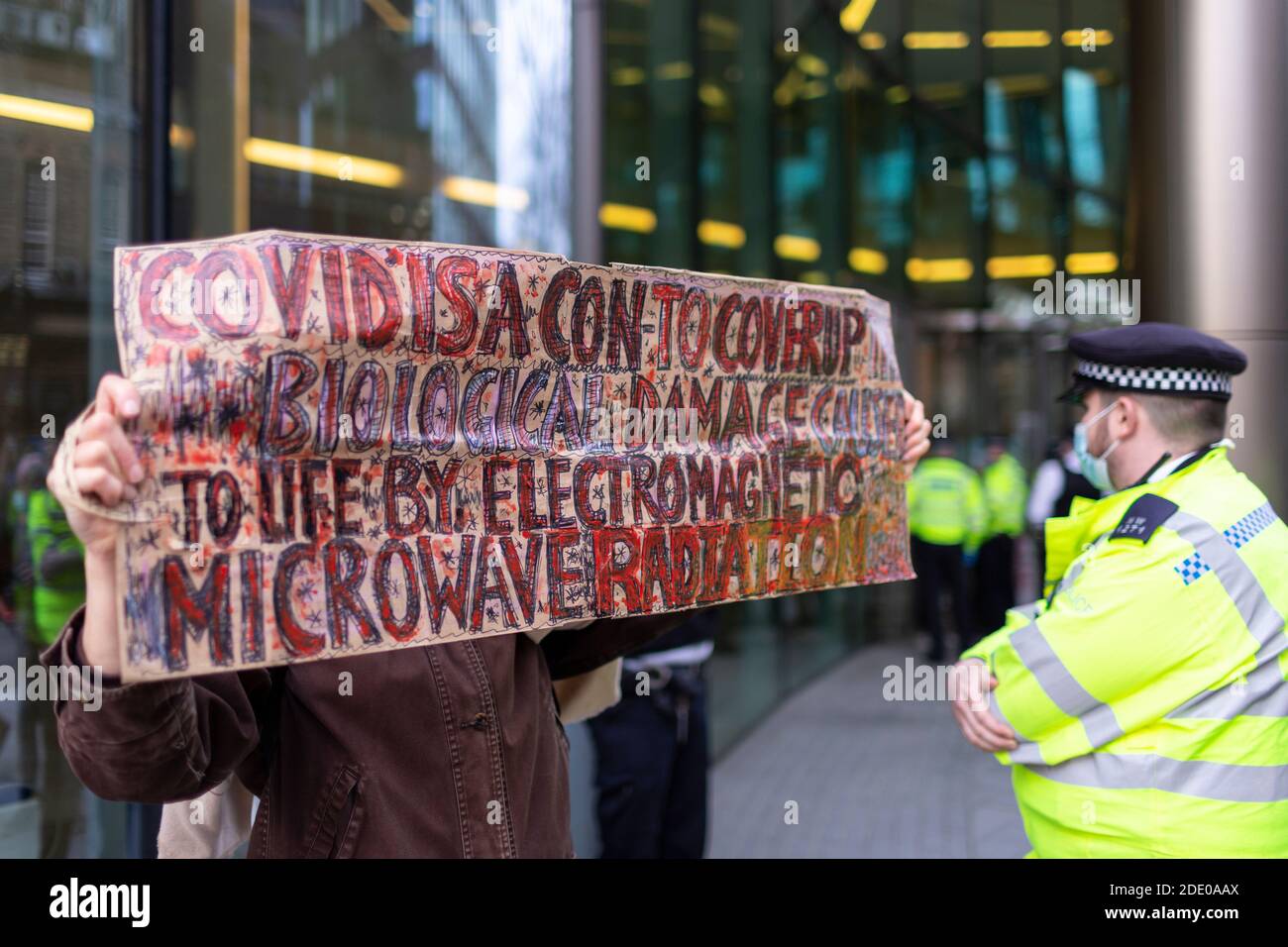 Manifestante che tiene la bandiera durante la protesta anti-vaccinazione, Bill e Melinda Gates Foundation Office, Londra, 24 novembre 2020 Foto Stock