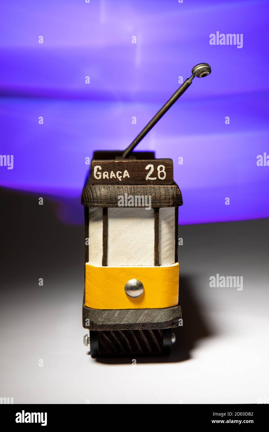 Piccolo modello in legno del tram giallo 28 di Lisbona con effetto luminoso sullo sfondo. Foto Stock