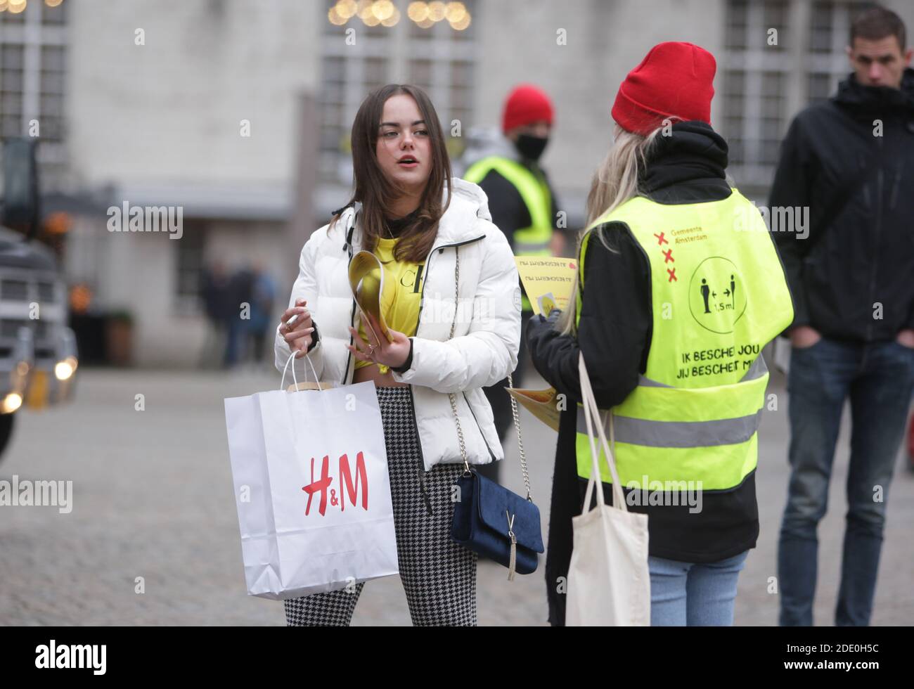 I dipendenti municipali distribuiscono poster per i consumatori per evitare luoghi affollati e mantenere la distanza sociale e indossare maschere facciali di protezione durante 'Frida nero Foto Stock