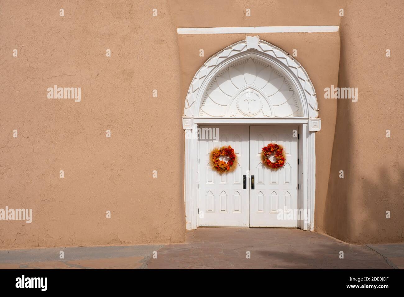 Porte d'ingresso bianche intagliate alla chiesa di adobe Mission di San Francisco de Asis - San Francesco d'Assi - a Ranchos de Taos, New Mexico, USA Foto Stock