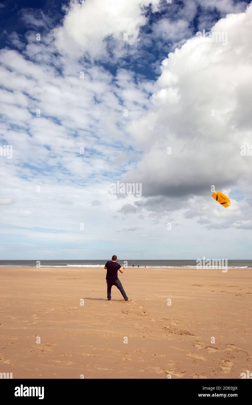 Il giovane uomo kite surf sulla spiaggia di Druridge Bay in Northumberland Foto Stock