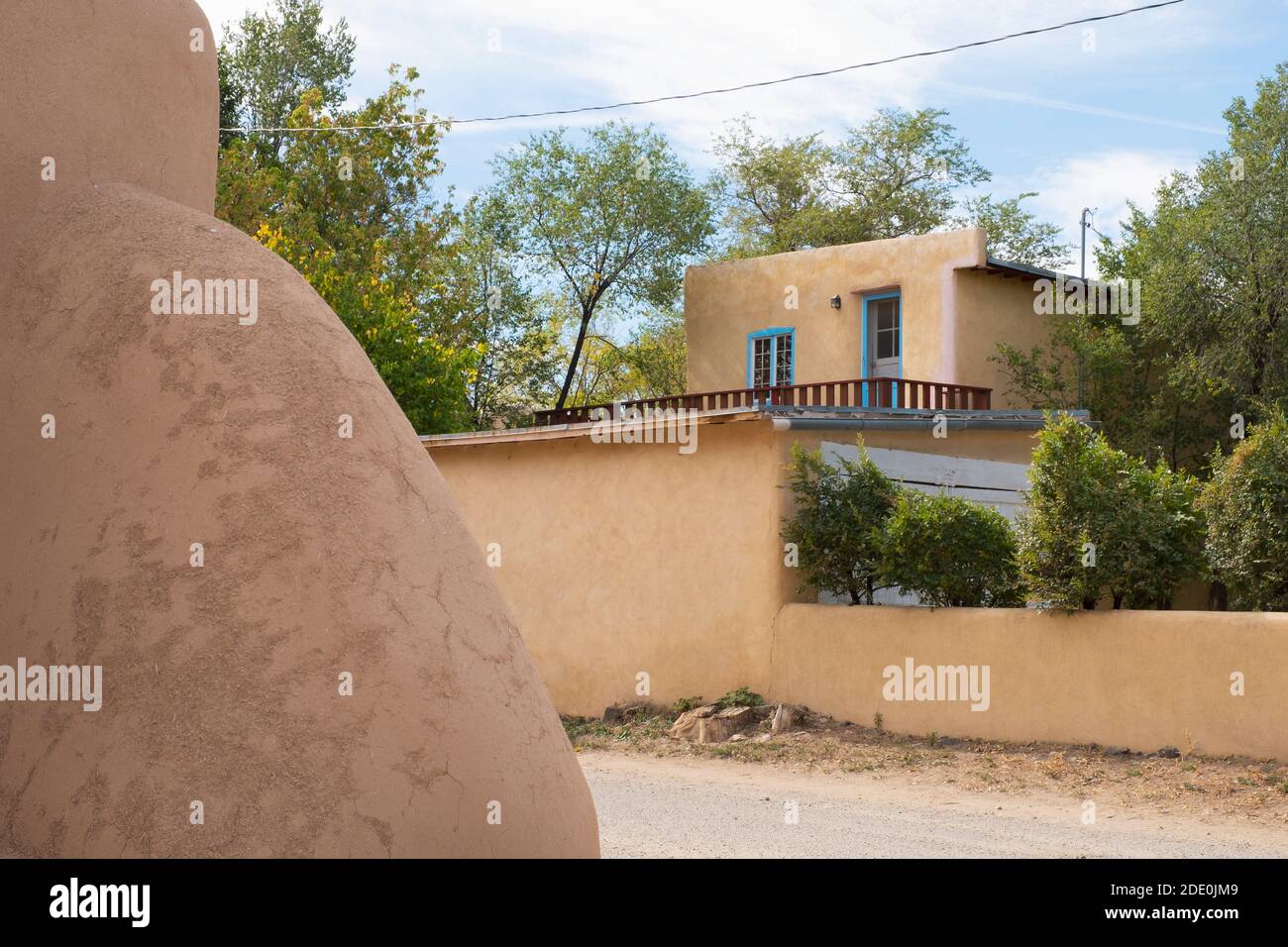 Architettura Adobe a Ranchos de Taos, New Mexico, USA. La chiesa della Missione di San Francisco de Asis in primo piano, e una casa privata dietro. Foto Stock