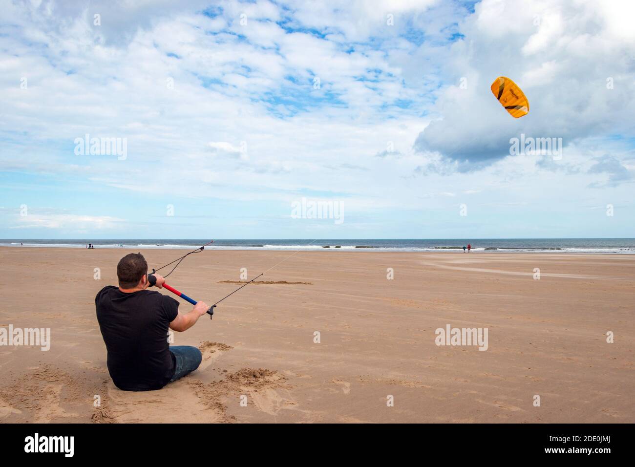 Il giovane uomo kite surf sulla spiaggia di Druridge Bay in Northumberland Foto Stock