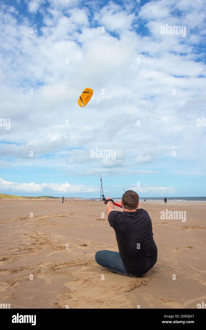 Il giovane uomo kite surf sulla spiaggia di Druridge Bay in Northumberland Foto Stock