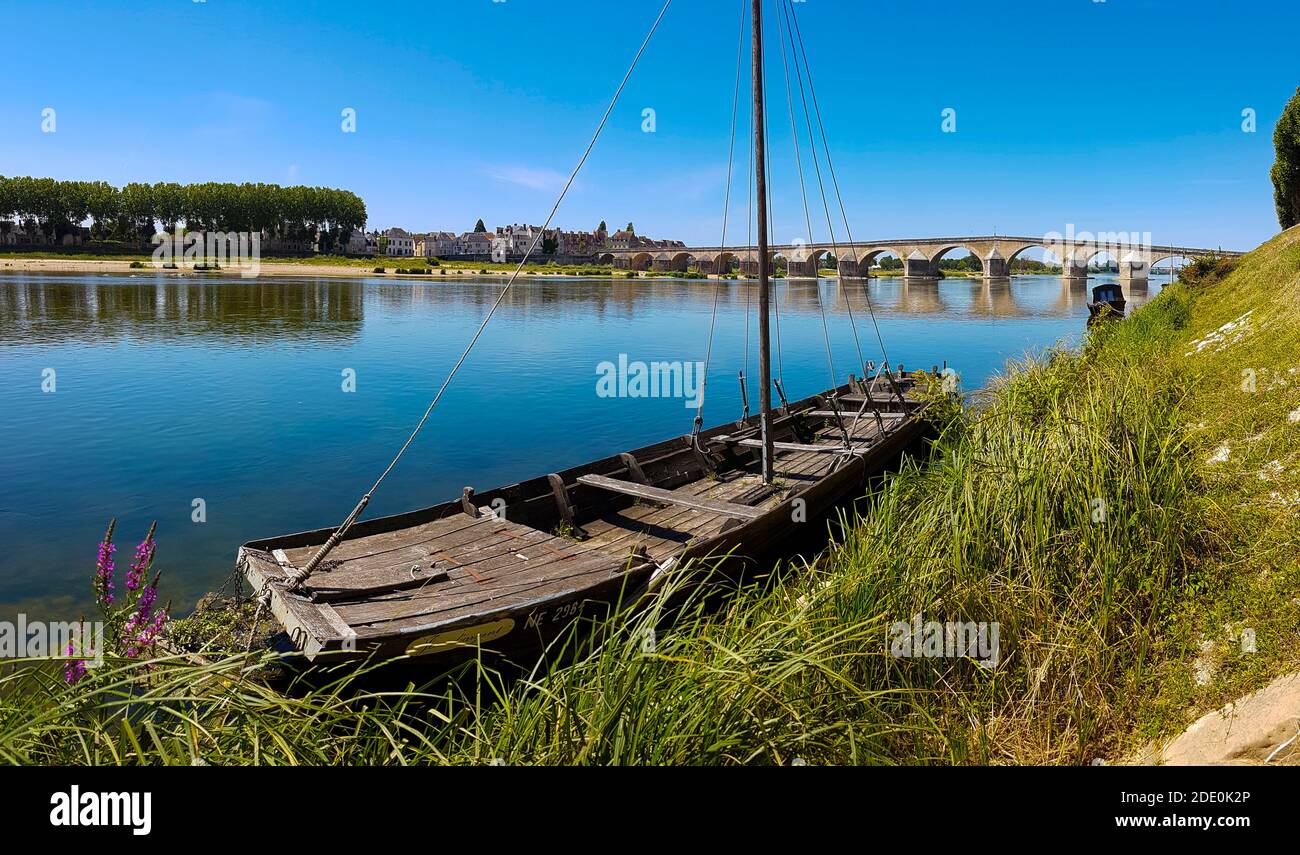 Francia, Loiret (45), Gien, barca tradizionale a fondo piatto chiamato in francese 'toue', Loira e indietro il vecchio ponte alsol chiamato Anne-de-Beaujeu br Foto Stock