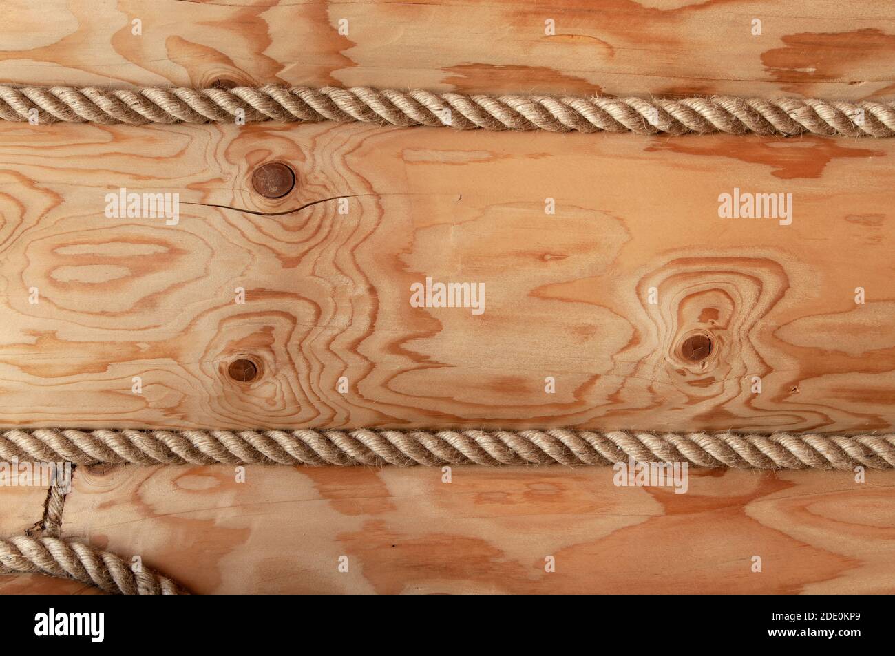 Parete di una casa di legno di tronchi decorata con corda decorativa. Texture in legno primo piano Foto Stock