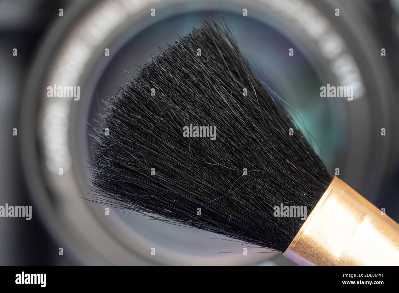 Una spazzola per la pulizia davanti all'obiettivo della fotocamera, primo piano. Foto Stock