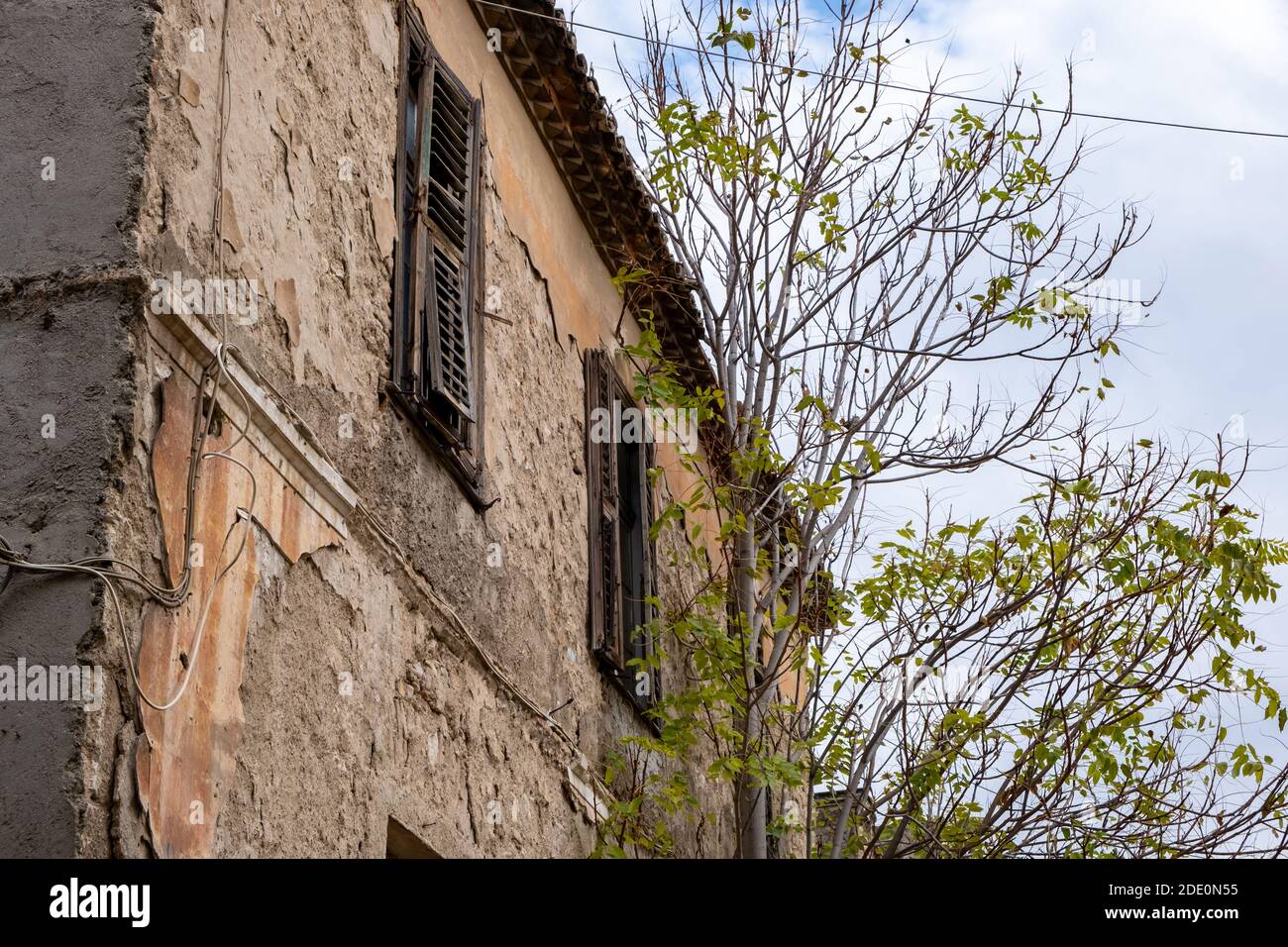 Rovinata facciata di un edificio abbandonato, cielo nuvoloso sfondo, Plaka, Atene Grecia. Vista ad angolo basso Foto Stock