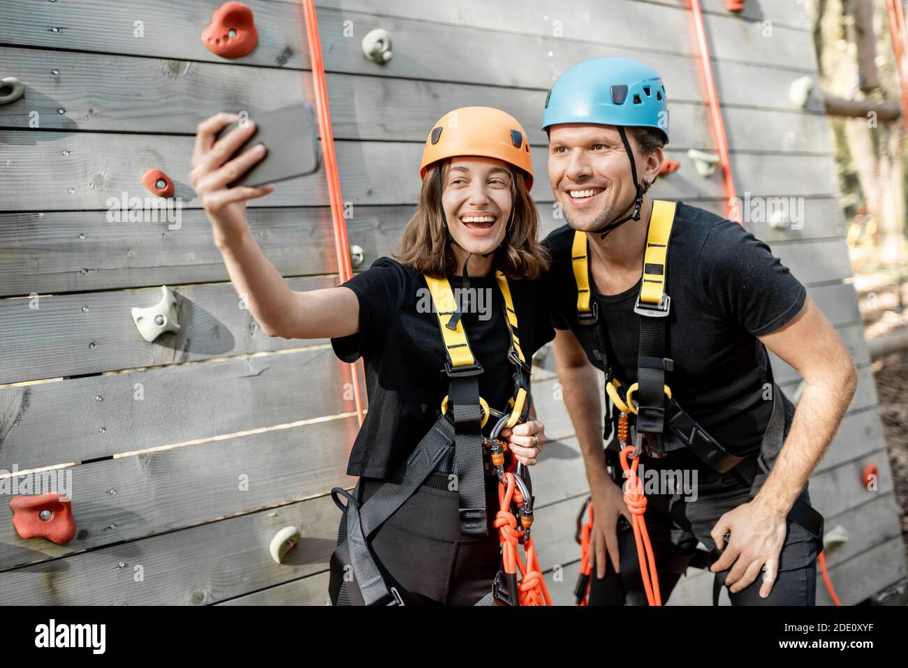 Amici in attrezzature sportive protettive scattando una foto selfie insieme, gli arrampicatori si sentono felici nel parco per l'intrattenimento sportivo Foto Stock