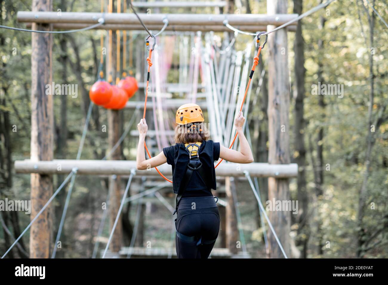 Giovane donna ben attrezzata con una ricreazione attiva, rampicanti nel parco con ostacoli all'aperto Foto Stock