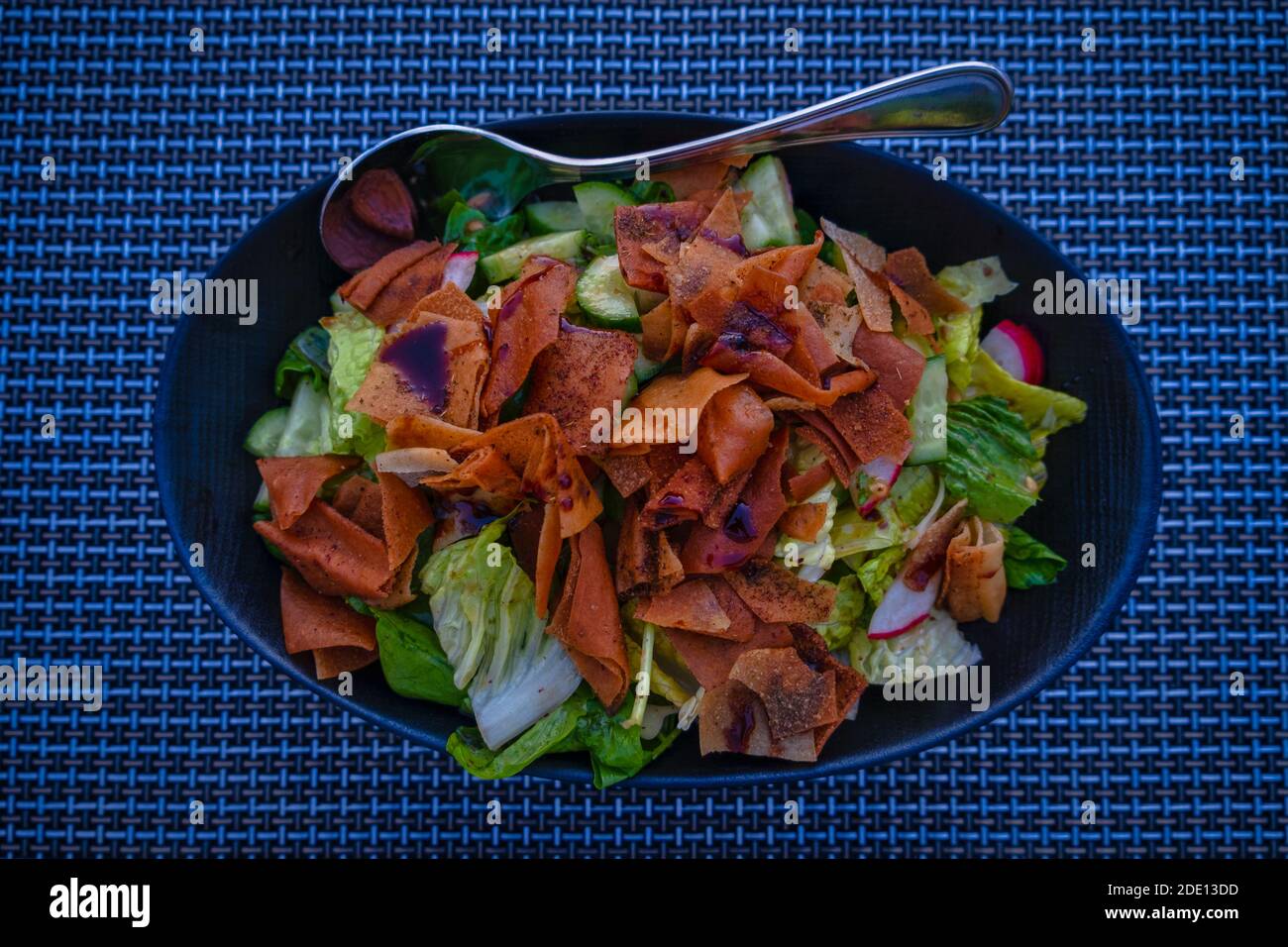Fatoush (insalata libanese) immagine ravvicinata in un piatto blu . E' fatto con verdure e pane piatto tostato croccante, che insafire il condimento Foto Stock