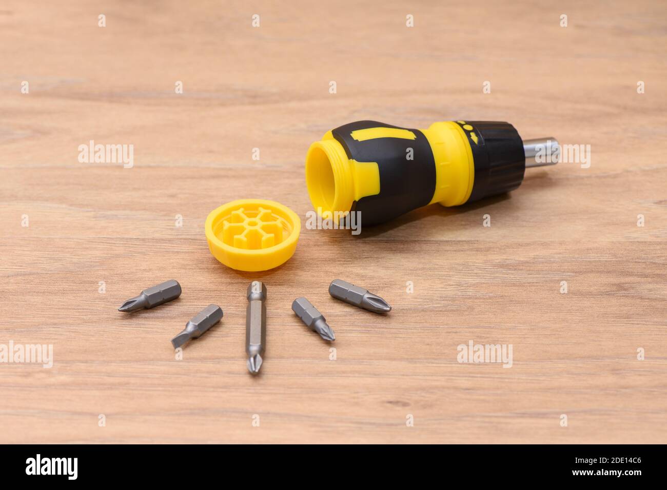 Fotografia a vita di un cacciavite giallo-nero. Fotografia macro dettagliata del set di punte per utensili multiuso compatte aperto. Foto Stock