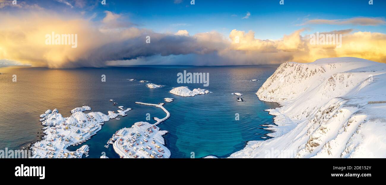 Cielo ardente all'alba sul freddo del mare e Sorvaer villaggio coperto di neve, Soroya Island, Hasvik, Troms og Finnmark, Artico, Norvegia Foto Stock