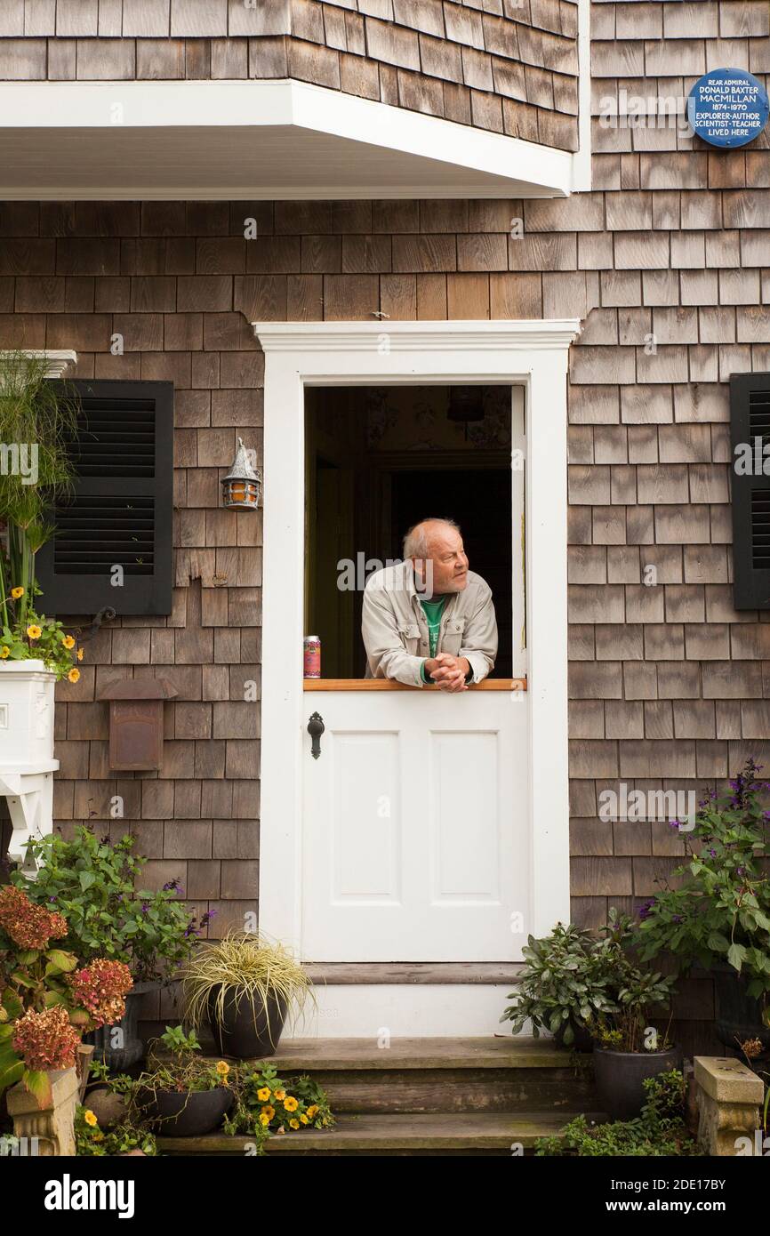 Un uomo si trova in fondo alla strada da una porta a Provincetown, Massachusetts. Foto Stock