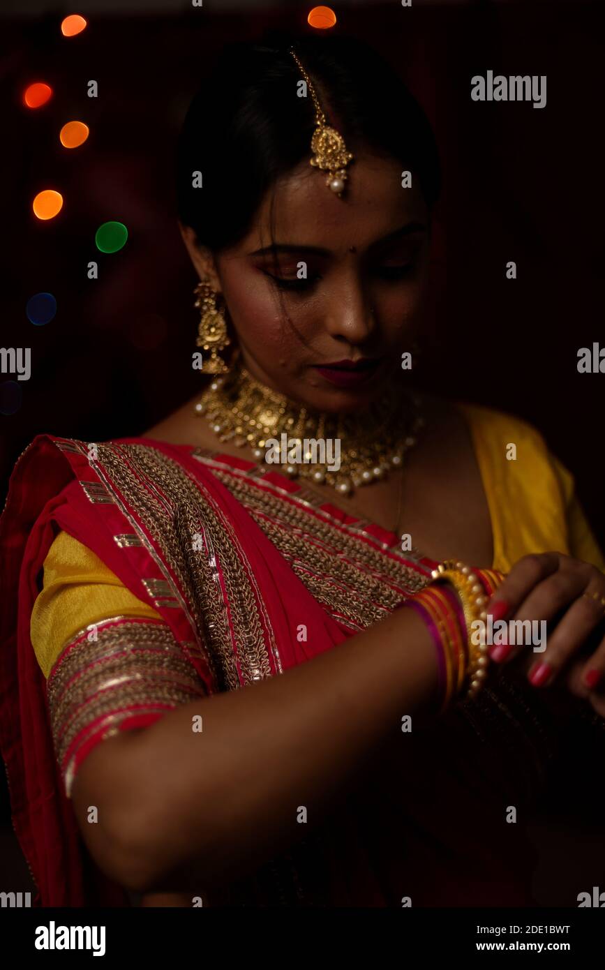 Ritratto di una bella donna bruna indiana bengalese di fronte al colorato sfondo chiaro bokeh la sera di Diwali. Stile di vita indiano Foto Stock