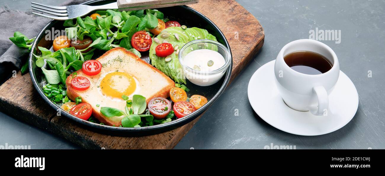 Uova fritte su pane con verdure. Colazione deliziosa e sana. Foto Stock