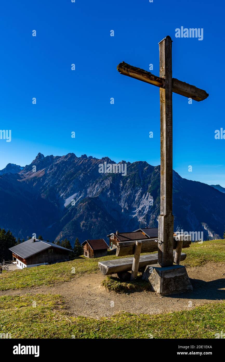 Herrliche Aussicht von Rellseck im Montafon bis ins Walgau. Viele Berge, eine Alp und ein Kreuz auf dem Hügel, Aussicht auf den Rhätikon Foto Stock